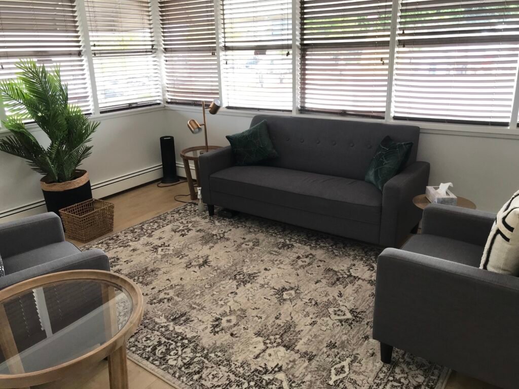 group counselling office with a couch, a few chairs, and bright windows in the background